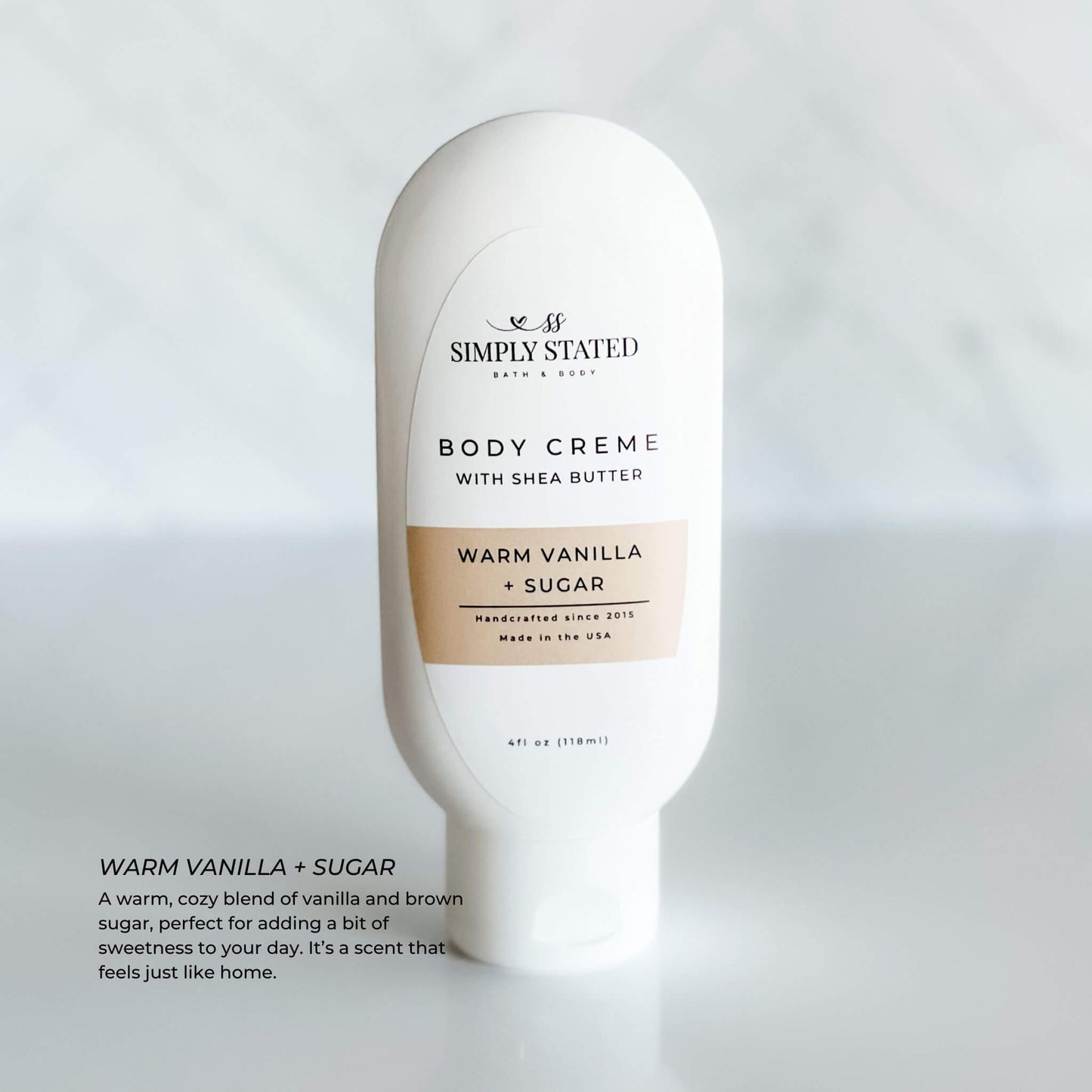 Simply Stated Body Creme in Warm Vanilla + Sugar scent. A 4oz squeeze bottle infused with shea butter and a cozy blend of vanilla and brown sugar. Provides luxurious hydration with a homey fragrance.